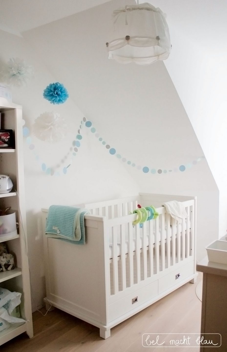 weißes Babybett (Kidsmill Shakery) mit Kreisgirlande und Pompoms in Mintfarben
